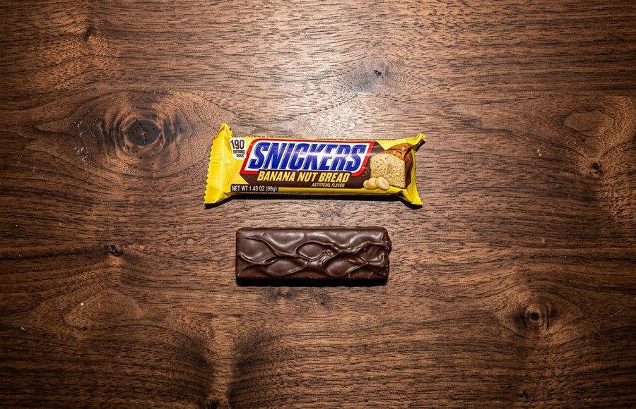 Snickers Banana Nut Bread candy bar displayed on a wood tabletop